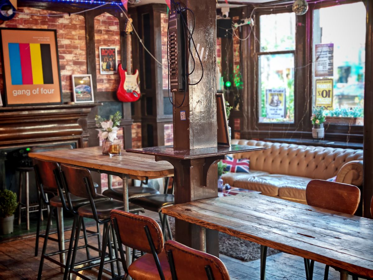 Warme, sfeervolle Britse pub met gedimd licht en houten tafels